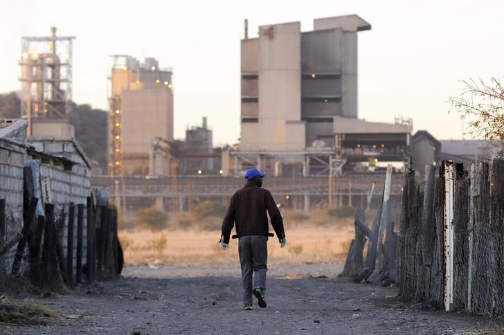 © Reuters. A township resident walks past Lonmin's Marikana platinum mine