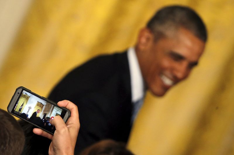 © Reuters. A guest takes a video of U.S. President Barack Obama with his mobile phone during a welcome reception for the WNBA Champions Phoenix Mercury team at the East Room of the White House in Washington