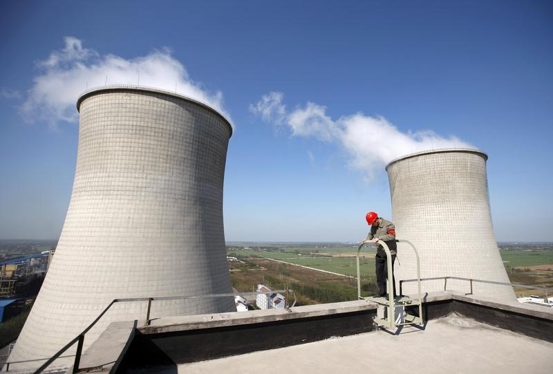 © Reuters. A labourer checks the power equipment at a power plant in Huaibei