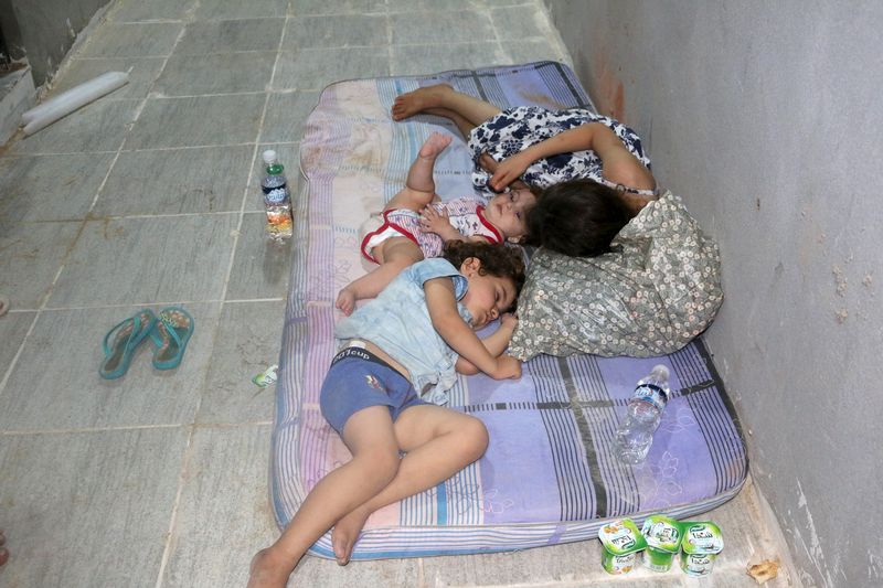 © Reuters. Surviving migrants rest at a detention center after their boat sank off the coastal town of Zuwara