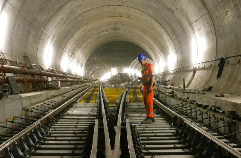 © Reuters. A worker checks the railway tracks during installation works in the NEAT Gotthard Base tunnel near Faido