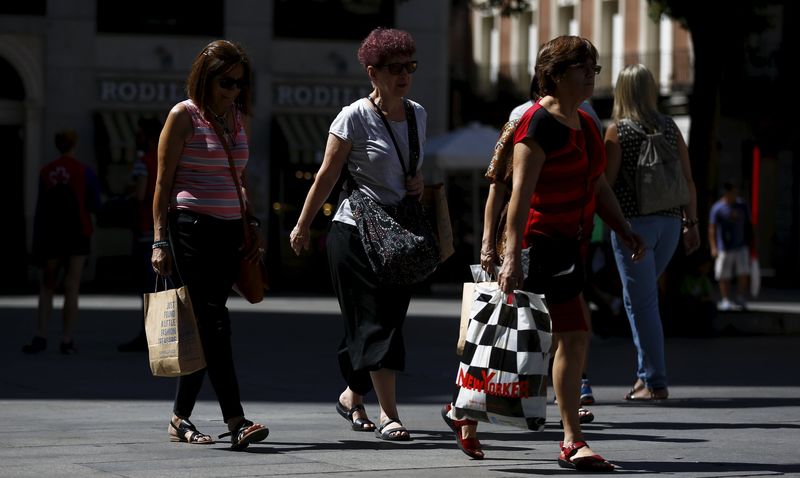 © Reuters. Women carry shopping bags as they walk in central Madrid