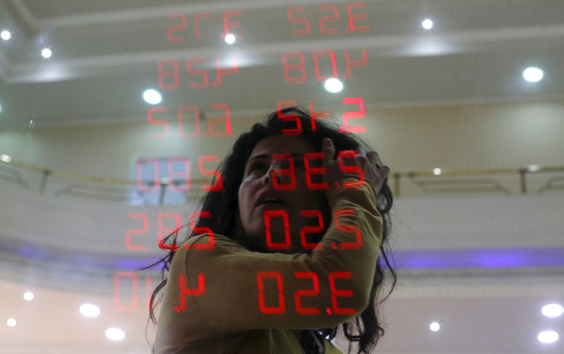 © Reuters. A woman reacts as she reads a board showing the Real-U.S. dollar and several foreign currencies exchange rates in Rio de Janeiro