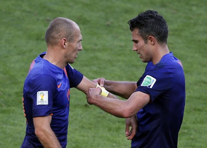 © Reuters. Robin Van Persie colocando a faixa de capitão em Arjen Robben, durante partida contra a Austrália na Copa do Mundo de 2014, no Brasil