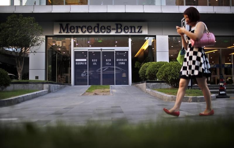 © Reuters. A woman walks past a Mercedez-Benz car dealership in downtown Shanghai
