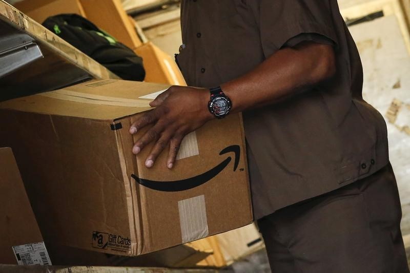 © Reuters. Worker carries an Amazon box to be delivered in New York