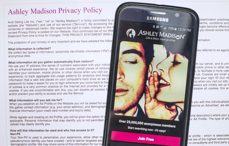 © Reuters. A photo illustration shows the privacy policy of the Ashley Madison website seen behind a smartphone running the Ashley Madison app in Toronto