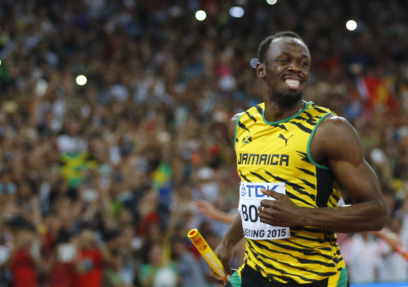 © Reuters. Bolt smiles after running the anchor leg to win the men's 4 x 100 metres relay final at the 15th IAAF Championships in Beijing