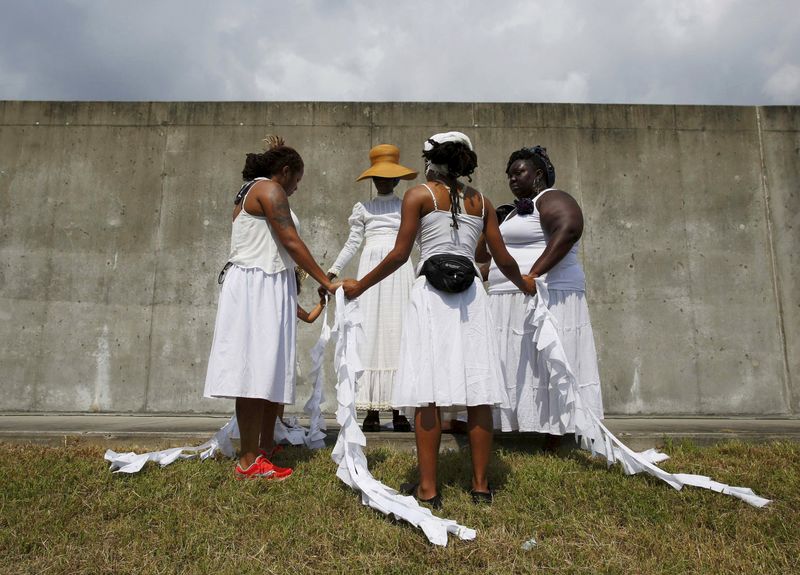 © Reuters. Women pray at the site of the 2005 Industrial Canal levee failure, during a ceremony marking the tenth anniversary of Hurricane Katrina in the Lower 9th Ward in New Orleans