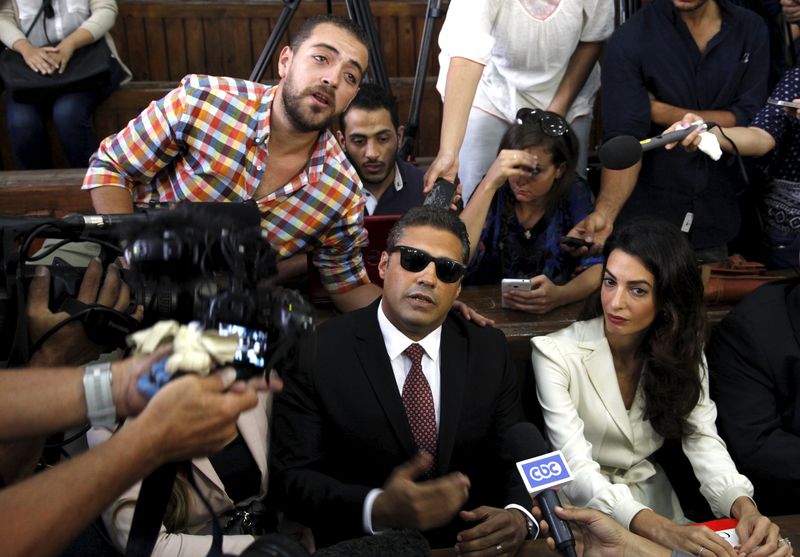 © Reuters. Fahmy and Baher Mohamed talk to the media before hearing the verdict at a court in Cairo