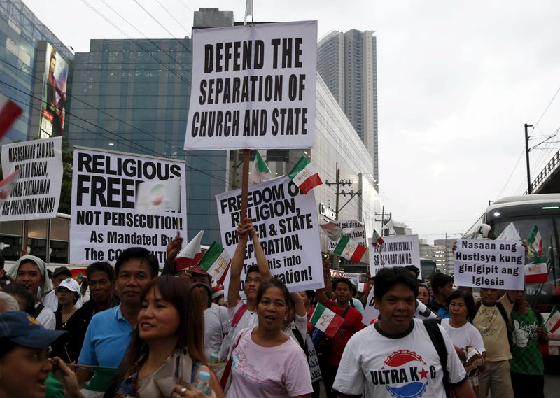 © Reuters. Protesters belonging to the Iglesia ni Cristo (Church of Christ) group display placards as they march along EDSA highway in Mandaluyong