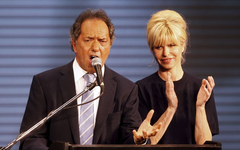 © Reuters. Daniel Scioli, Buenos Aires' province governor and presidential candidate speaks next to his wife Karina Rabolini in Buenos Aires