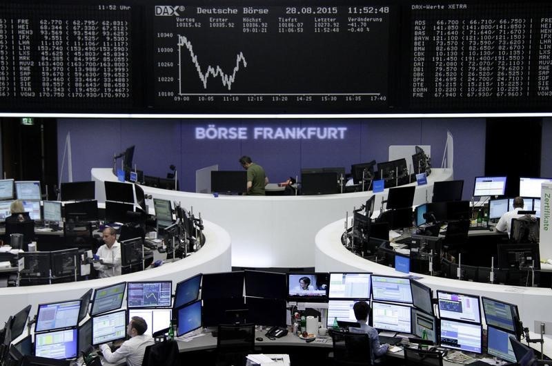 © Reuters. Traders are pictured at their desks in front of the DAX board at the Frankfurt stock exchange