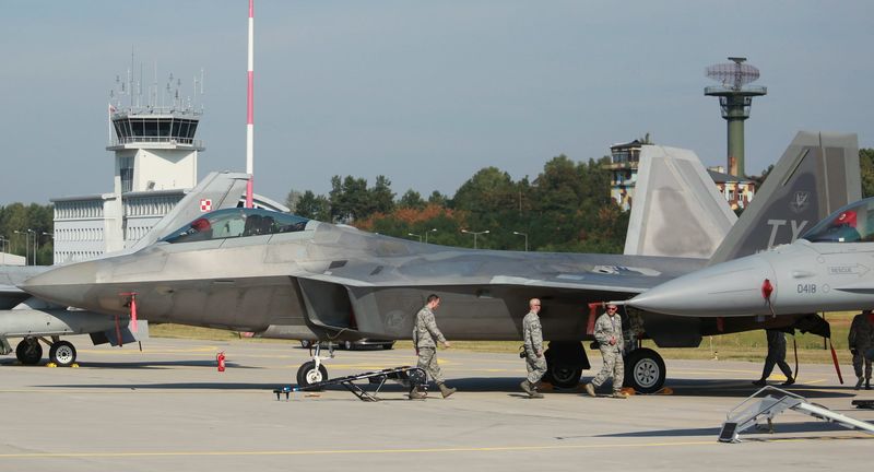 © Reuters. Soldados norte-americanos ao lado de caças F-22 na base da Força Aérea polonesa de Lask