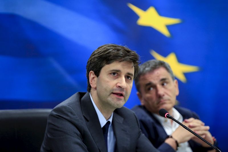 © Reuters. Greek newly appointed interim Finance Minister Chouliarakis addresses journalists next to outgoing Finance Minister Tsakalotos during a handover ceremony at the ministry in Athens