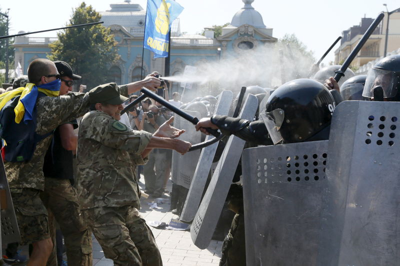 © Reuters. Demonstrators, who are against a constitutional amendment on decentralization, clash with police outside the parliament building in Kiev