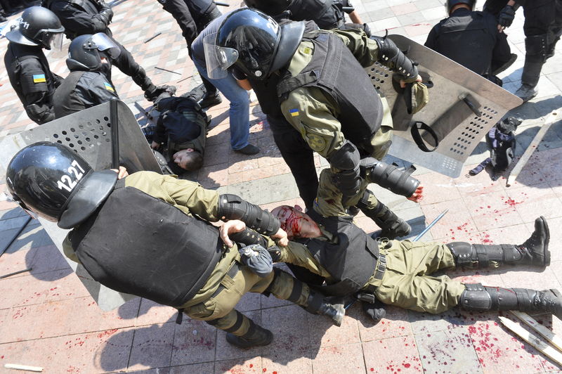 © Reuters. An injured national guard officer is carried away by comrades outside the parliament building in Kiev