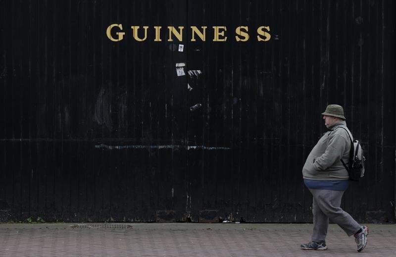 © Reuters. A man passes the Guinness beer factory in the city centre of Dublin