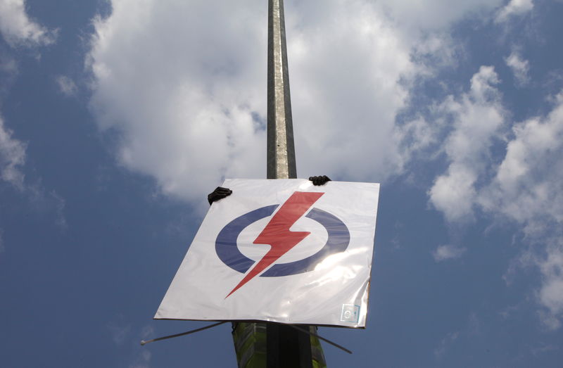 © Reuters. Worker puts up a People's Action Party (PAP) sign on a street lamp ahead of the general election in Singapore 