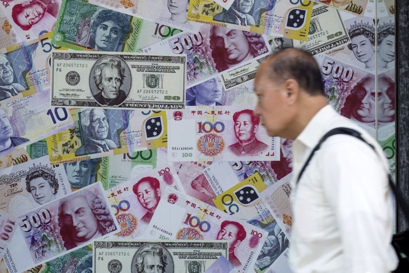 © Reuters. A man walks past an advertisement promoting China's renminbi (RMB) or yuan, U.S. dollar and Euro exchange services at foreign exchange store in Hong Kong