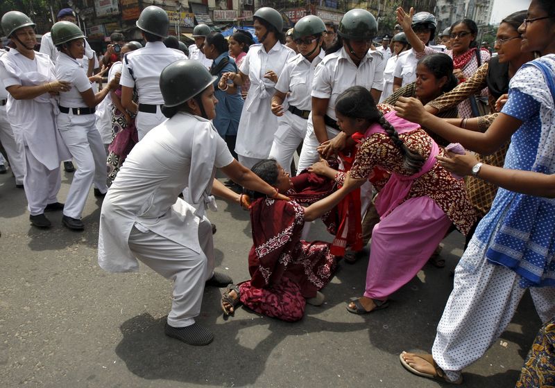 © Reuters. Policewomen try to detain activists from SUCI during a nationwide strike in Kolkata