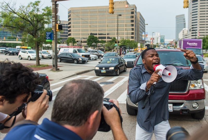 © Reuters. A protester blocks traffic as protests moved into the street on the first day of pretrial motions for six police officers charged in connection with the death of Freddie Gray in Baltimore