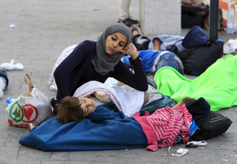 © Reuters. Imigrantes descansam no lado de fora de uma estação ferroviária em Budapeste