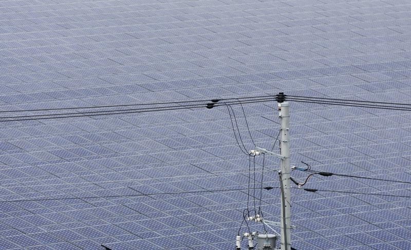 © Reuters. Power lines are seen in front of solar panels at a solar power field in Kawasaki