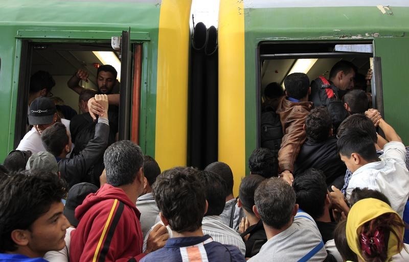 © Reuters.  Cientos de inmigrantes acceden a un tren en Budapest tras retirarse la policía