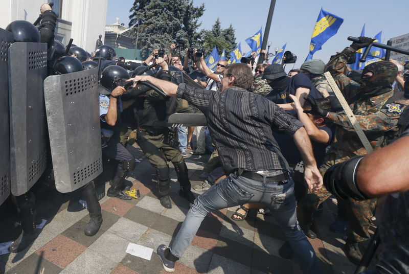 © Reuters. Demonstrators, who are against a constitutional amendment on decentralization, clash with police outside the parliament building in Kiev