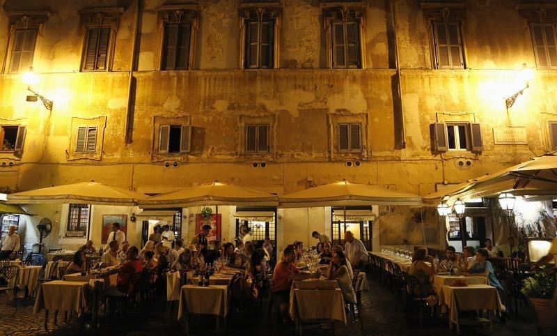 © Reuters. Customers eat dinner at a restaurant in downtown Rome