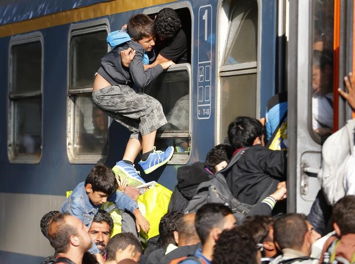 © Reuters. Imigrantes entram em trem na estação de Keleti, em Budapeste