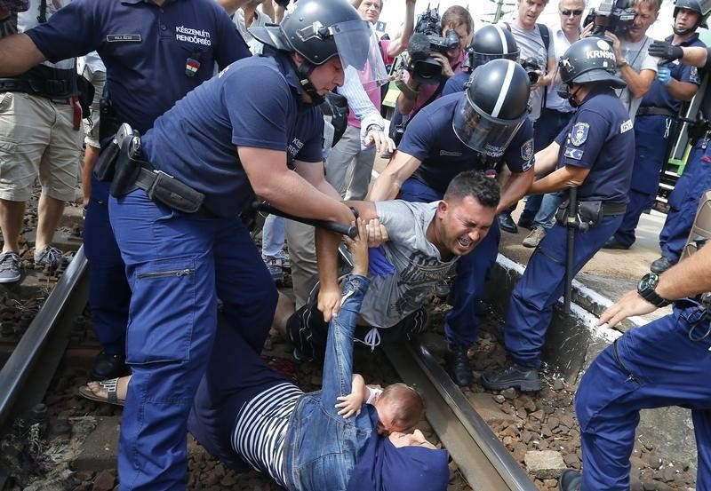 © Reuters. Policiais húngaros detêm imigrantes nos trilhos de trem na cidade de Bicske