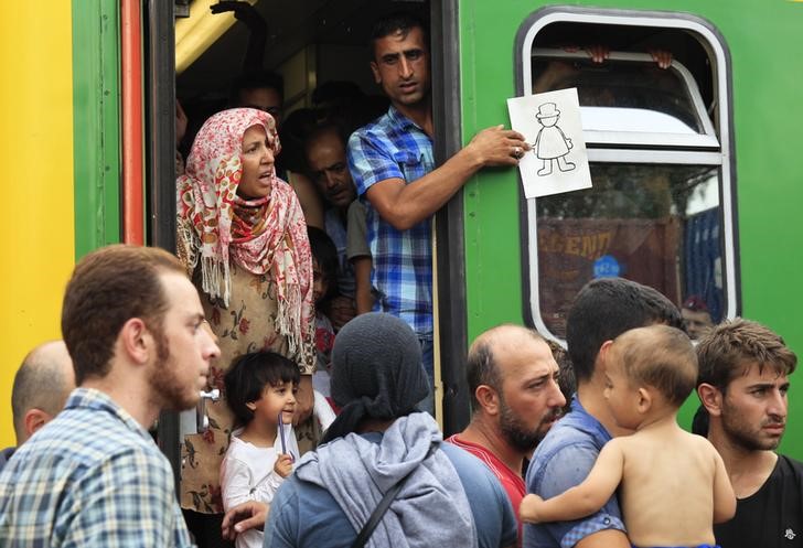 © Reuters. Policía húngara saca a inmigrantes de trenes que iban hacia Austria