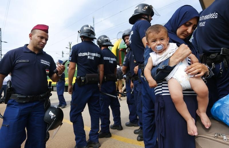 © Reuters. مواجهة بين شرطة المجر ومهاجرين أثناء محاولتها إنزالهم من قطار