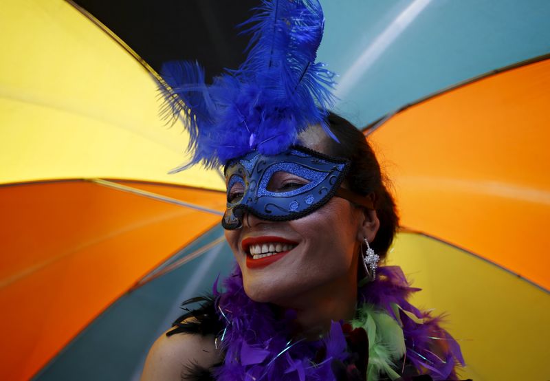 © Reuters. A reveller carrying an umbrella takes part in a LGBT (lesbian, gay, bisexual, and transgender) pride parade to mark the Gaijatra Festival, also known as the festival of cows, in Kathmandu