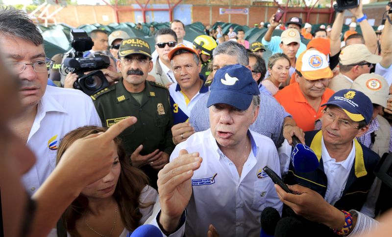 © Reuters. Presidente colombiano Juan Manuel Santos fala com família deportada da Venezuela 