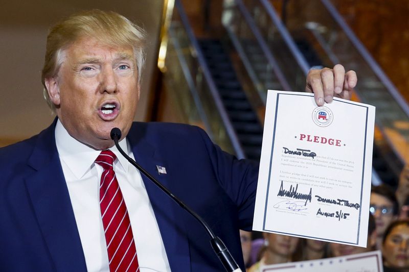 © Reuters. Pré-candidato republicano à Presidência dos Estados Unidos Donald Trump mostra promessa assinada por ele durante entrevista coletiva na Trump Tower, em Nova York 