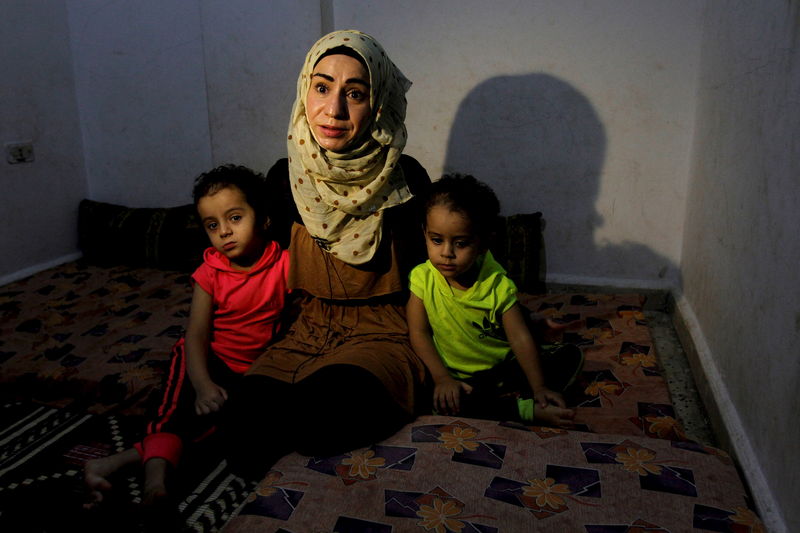 © Reuters. Manal al-Naji, com seus dois filhos, concede entrevista à Reuters em campo de refugiados