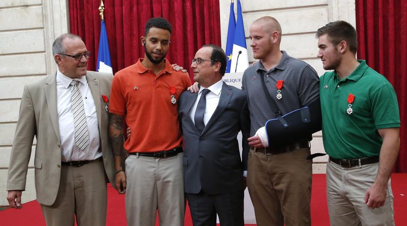 © Reuters. French President Hollande poses with British businessman Chris Norman, US student Anthony Sadler, US Airman First Class Spencer Stone and US National Guardsman Alek Skarlatos during a ceremony at the Elysee Palace in Paris