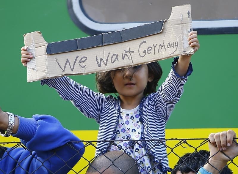 © Reuters. Bickse, Ungheria, oggi: una bambina tiene in mano un cartello improvisato con scritto "Vogliamo la Germania" durante una protesta alla stazione ferroviaria