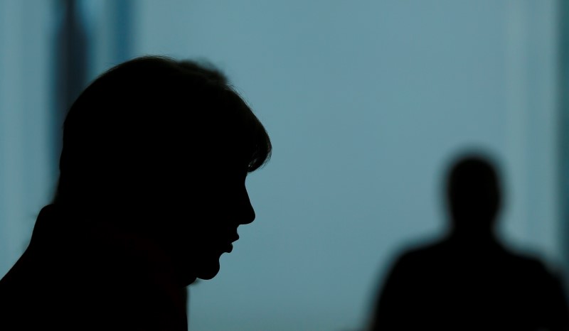 © Reuters. German Chancellor Merkel is silhouetted as she addresses an annual news conference in Berlin