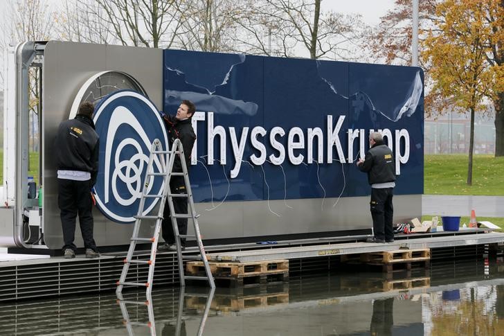 © Reuters. Electricians carry a cover with the logo of ThyssenKrupp AG at the company's headquarters in the western German city of Essen
