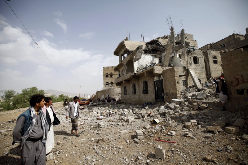 © Reuters. People look at the rubble of a house destroyed by a Saudi-led airstrike in Yemen's capital Sanaa