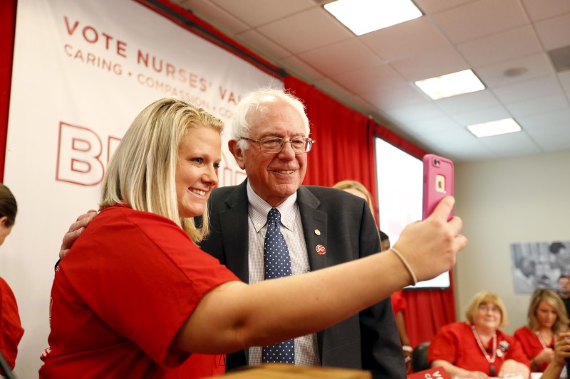 © Reuters. File photo of Vermont Senator and U.S. Democratic presidential candidate Bernie Sanders taking a selfie with a supporter during a "Brunch With Bernie" rally at National Nurses United in Oakland