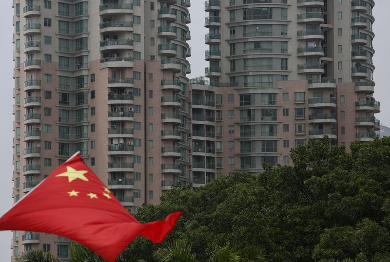 © Reuters. A Chinese national flag flutters in front of an apartment tower in the southern Chinese city of Shenzhen
