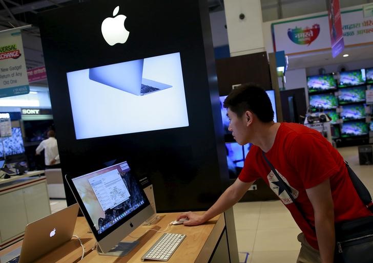 © Reuters. A man inspects an Apple iMac at an electronics store in Mumbai