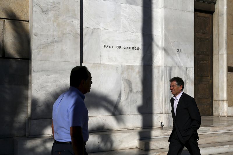 © Reuters. People walk past the headquarters of Bank of Greece in Athens