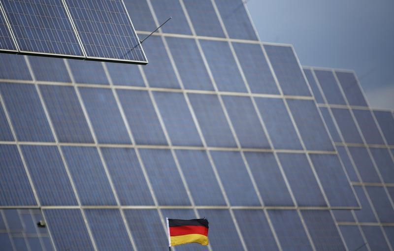 © Reuters. A German national flag is pictured in front of solar panels in Bad Hersfeld