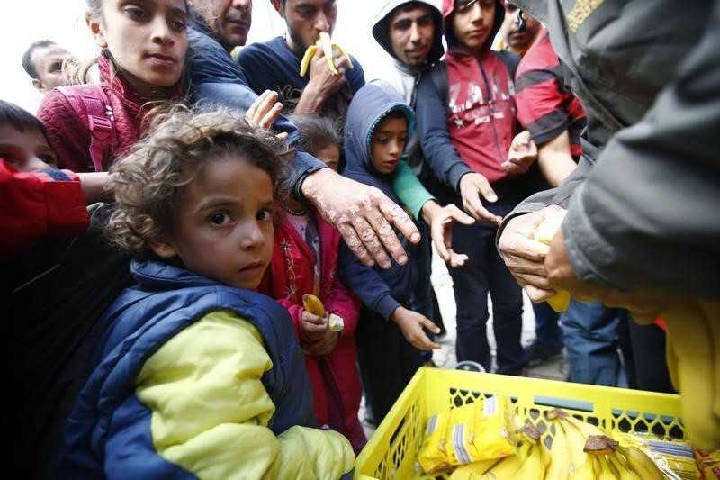 © Reuters. Food is distributed to migrants as they wait for trains at the railway station in Hegyeshalom